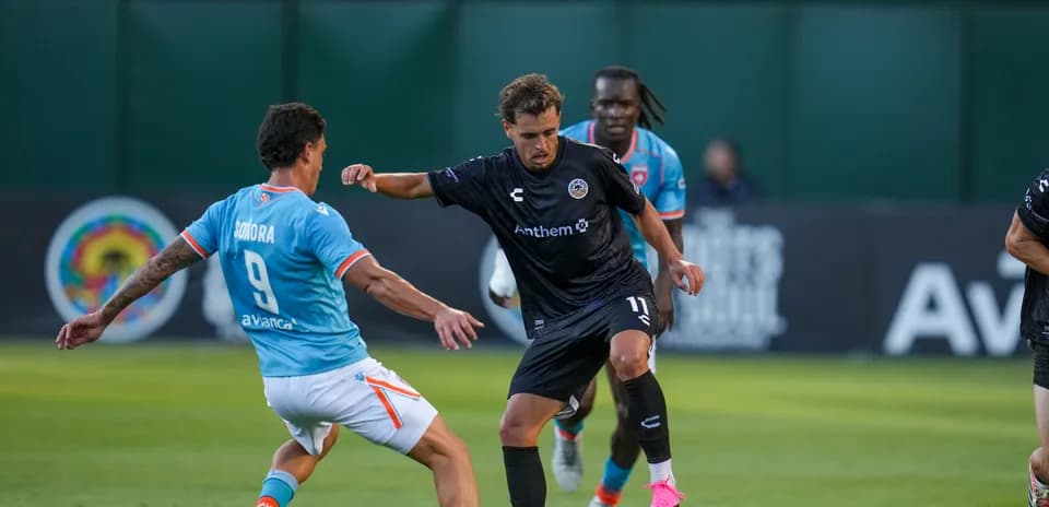 Jugador driblando en partido de fútbol