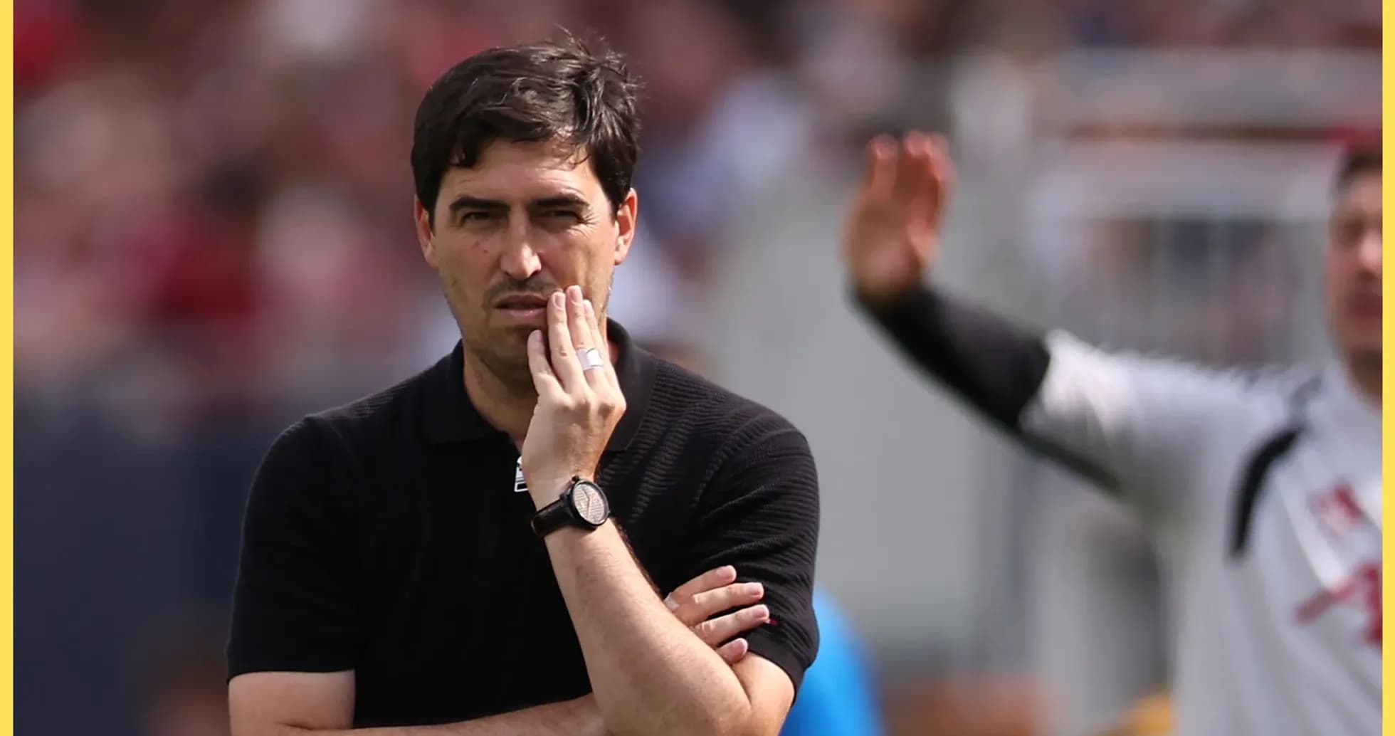Entrenador observando el partido con gesto pensativo