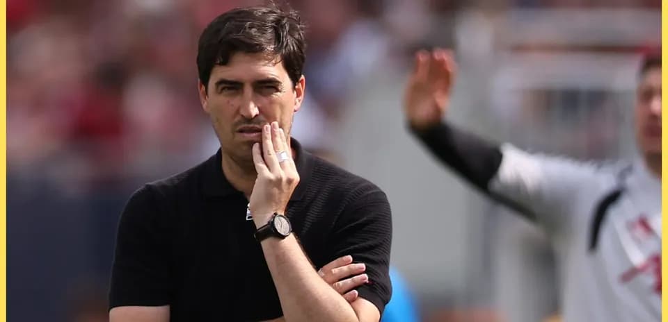 Entrenador observando el partido con gesto pensativo