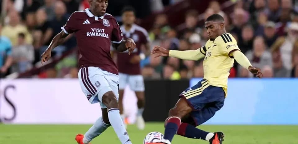 Jugador de Aston Villa desafiando a rival de Arsenal