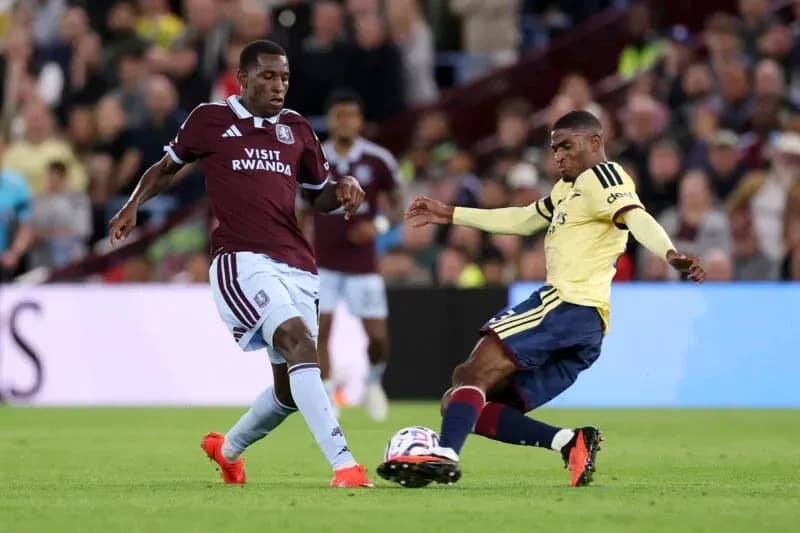 Jugador de Aston Villa desafiando a rival de Arsenal