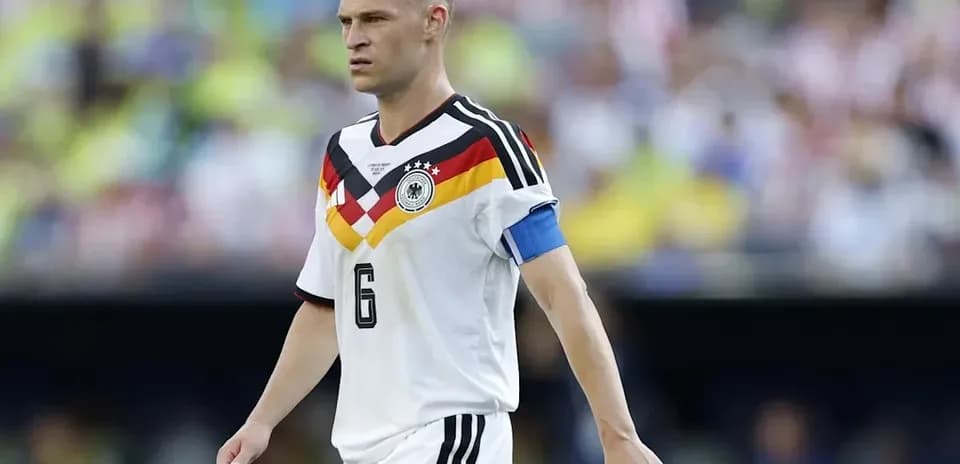 Jugador alemán con camiseta blanca y brazalete en campo