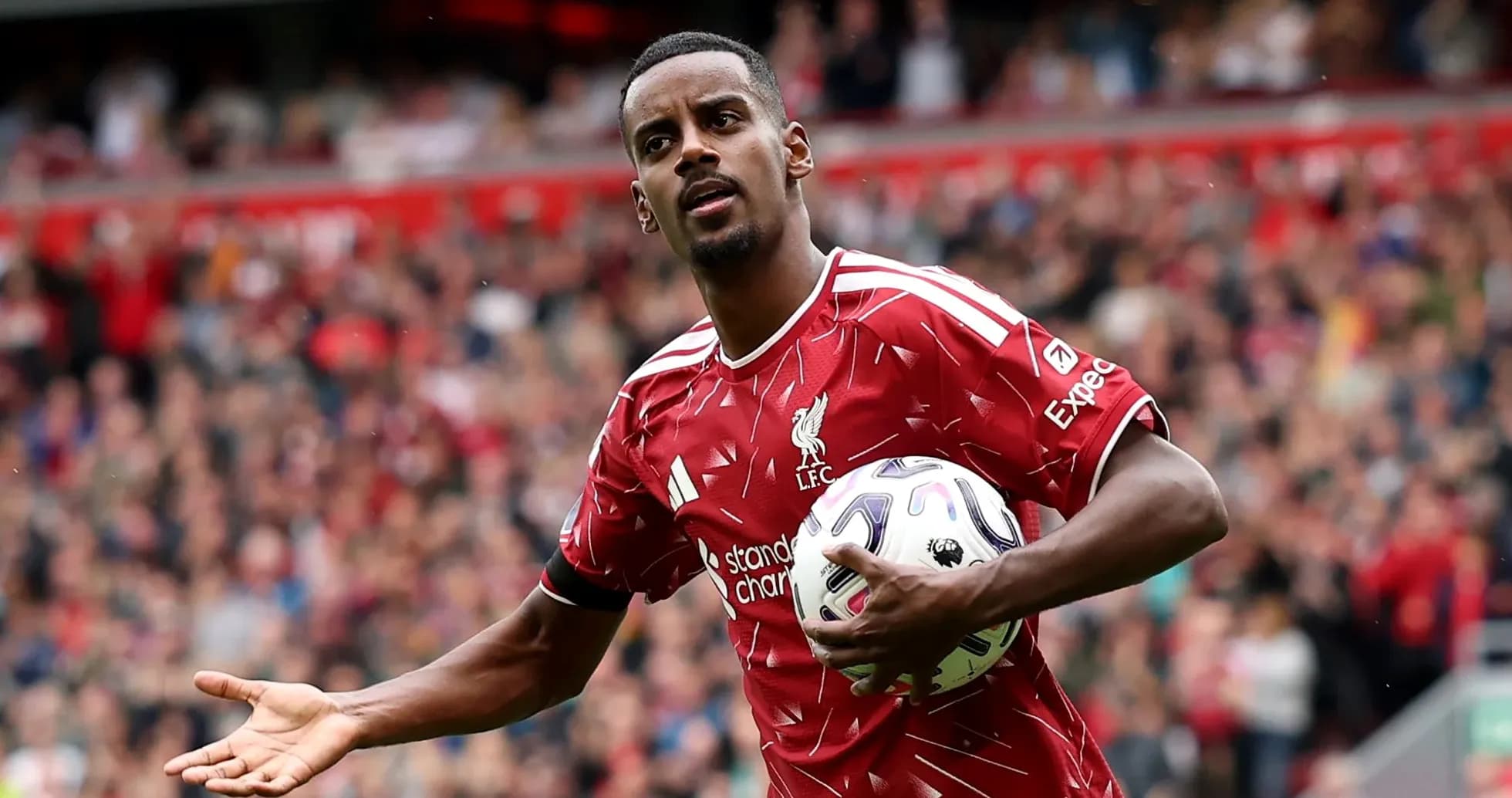 Jugador de Liverpool sosteniendo un balón en el campo