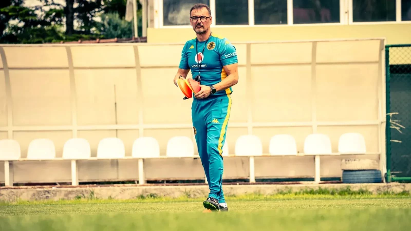 Entrenador con conos en el campo de entrenamiento