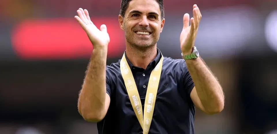 Entrenador aplaudiendo con medalla alrededor del cuello