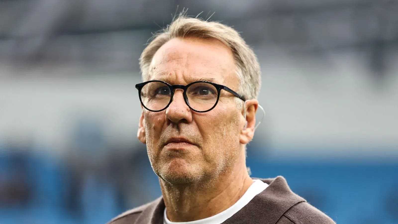 Hombre con gafas observando un partido de fútbol