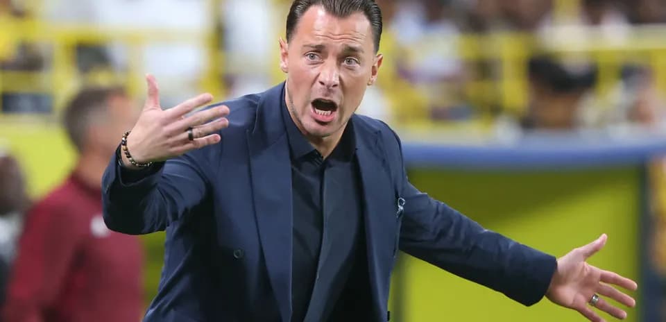 Entrenador gesticulando en el área técnica durante partido