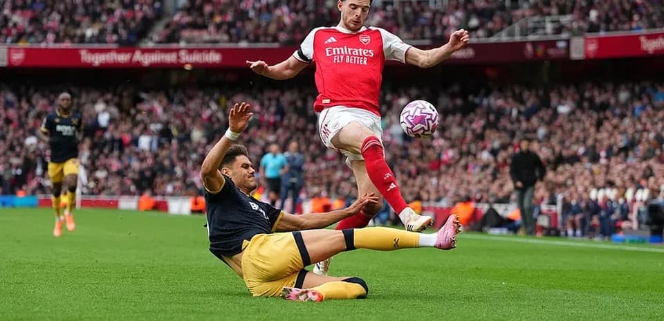 Jugador de Arsenal esquivando a un oponente de West Ham