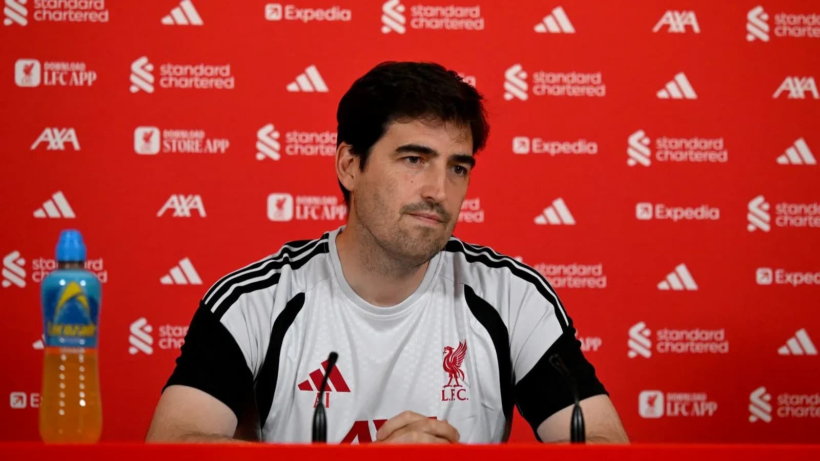 Entrenador en conferencia de prensa con fondo rojo