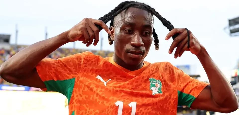 Jugador de fútbol ajustando su peinado en el campo