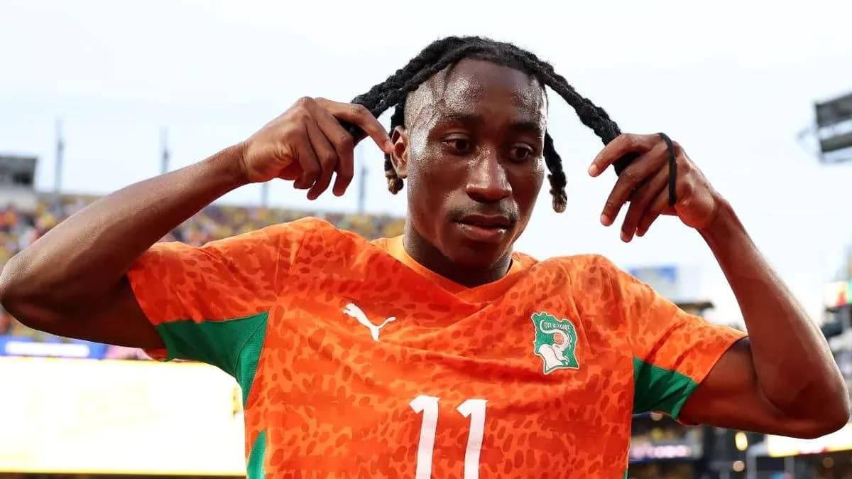 Jugador de fútbol ajustando su peinado en el campo