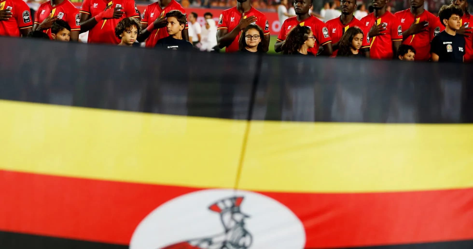 Jugadores de Uganda junto a la bandera nacional