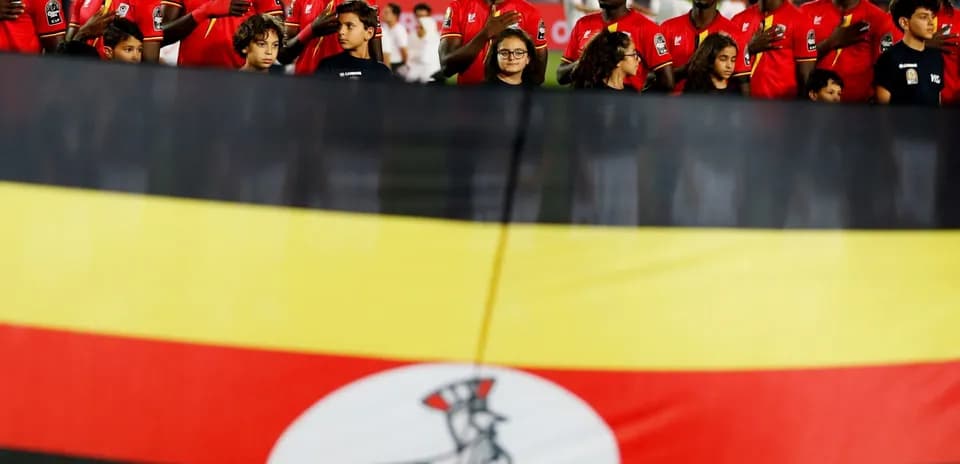 Jugadores de Uganda junto a la bandera nacional