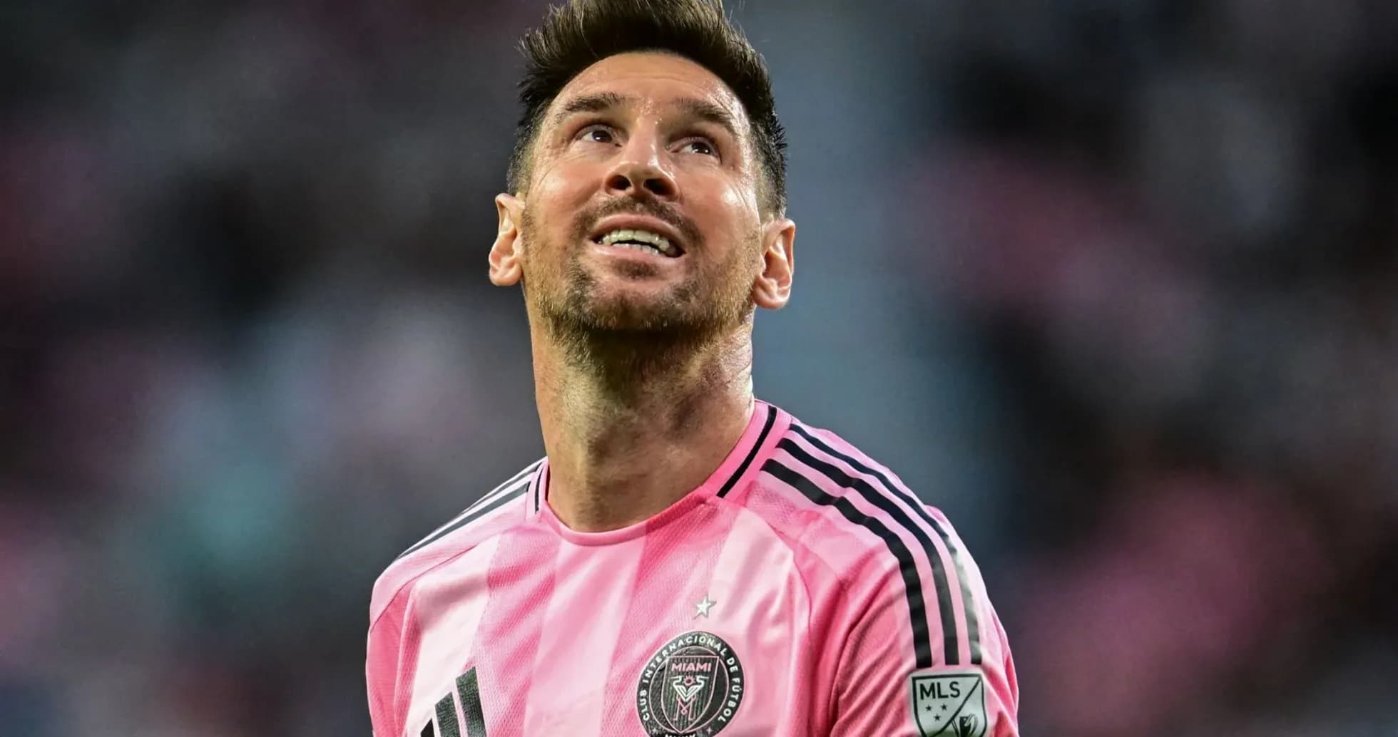 Jugador de fútbol con camiseta rosa mirando hacia arriba
