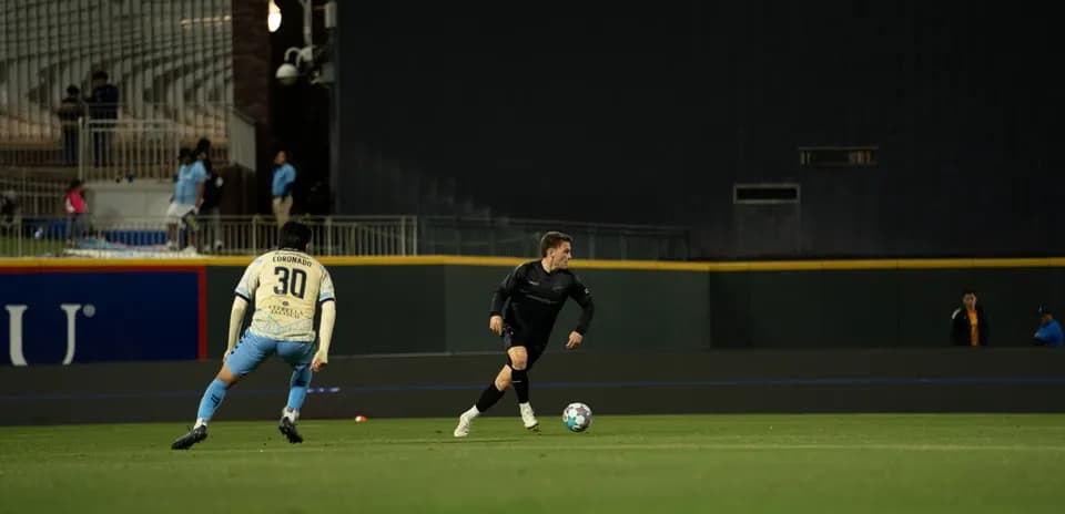 Jugador de Colorado Springs driblando a defensor