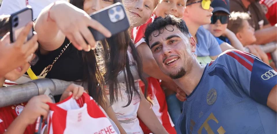 Jugador sonriendo con fans en evento deportivo