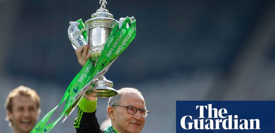 Entrenador levantando trofeo con cintas verdes