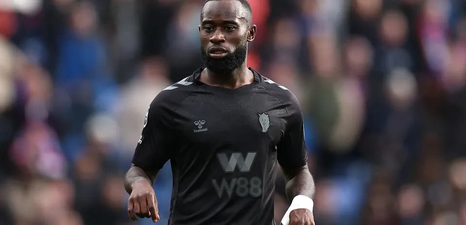 Jugador en uniforme negro caminando por el campo