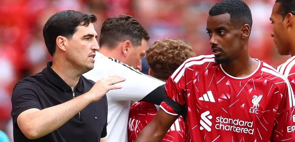 Entrenador hablando con jugador del Liverpool antes del partido