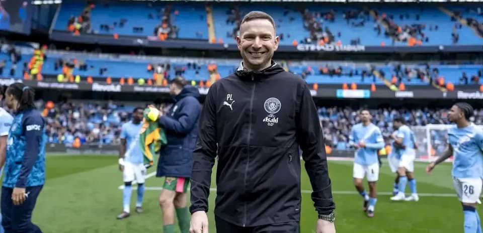 Entrenador sonriendo al final del partido en estadio