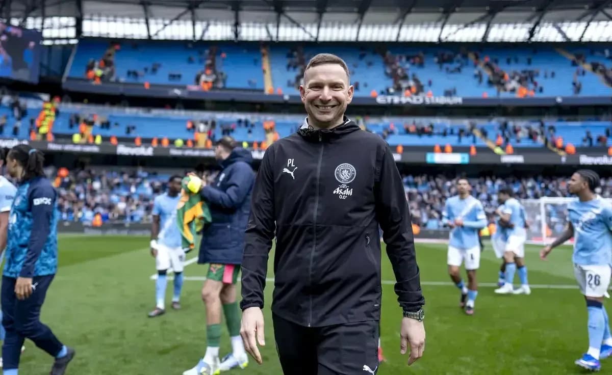 Entrenador sonriendo al final del partido en estadio