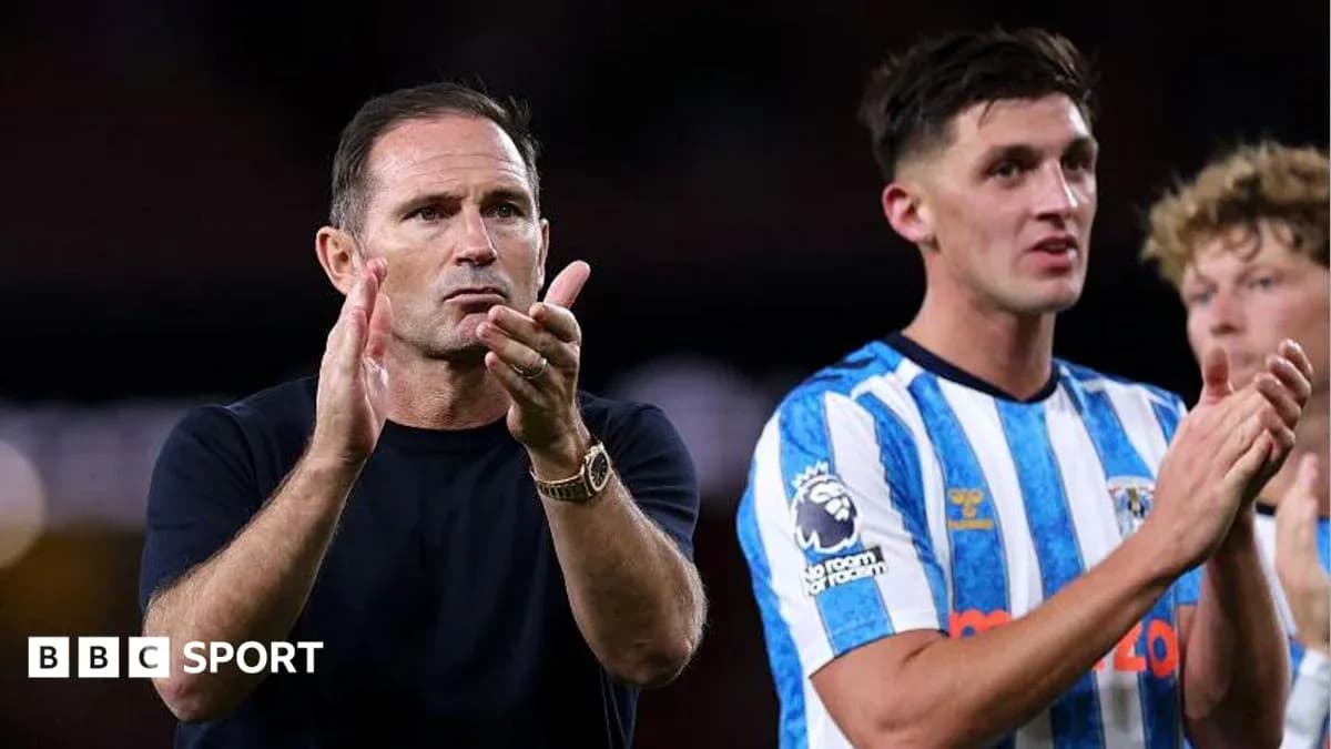 Entrenador aplaudiendo junto a jugadores en el campo