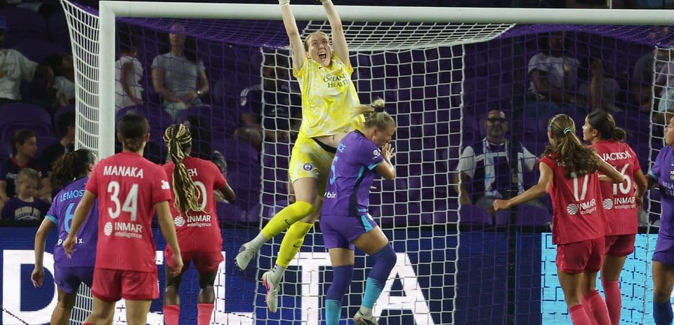 Portera atrapando el balón en el partido