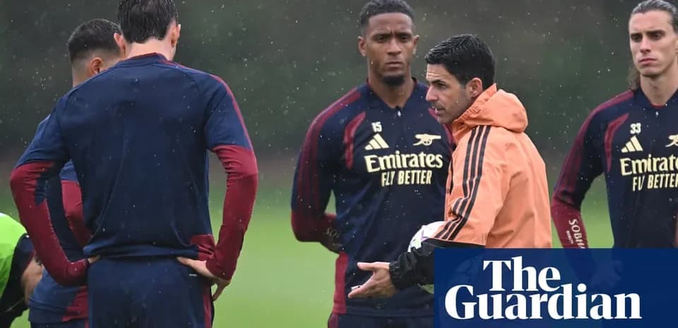 Entrenador hablando con jugadores durante entrenamiento bajo lluvia