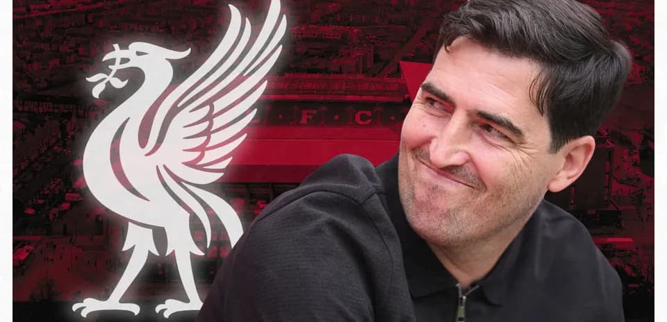 Entrenador sonriente frente al logo de Liverpool FC
