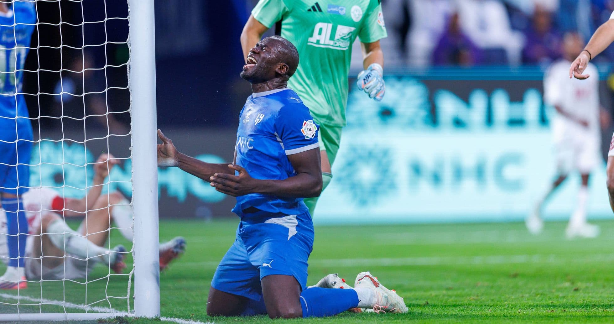 Jugador en uniforme azul arrodillado tras fallo en gol