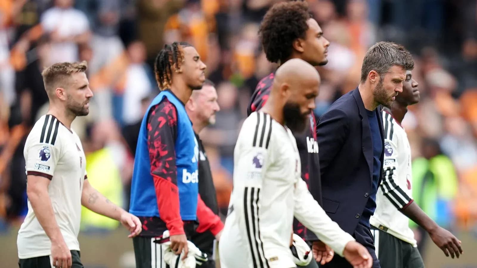 Jugadores y entrenador saliendo del campo tras partido Jugadores y entrenador saliendo del campo tras partido