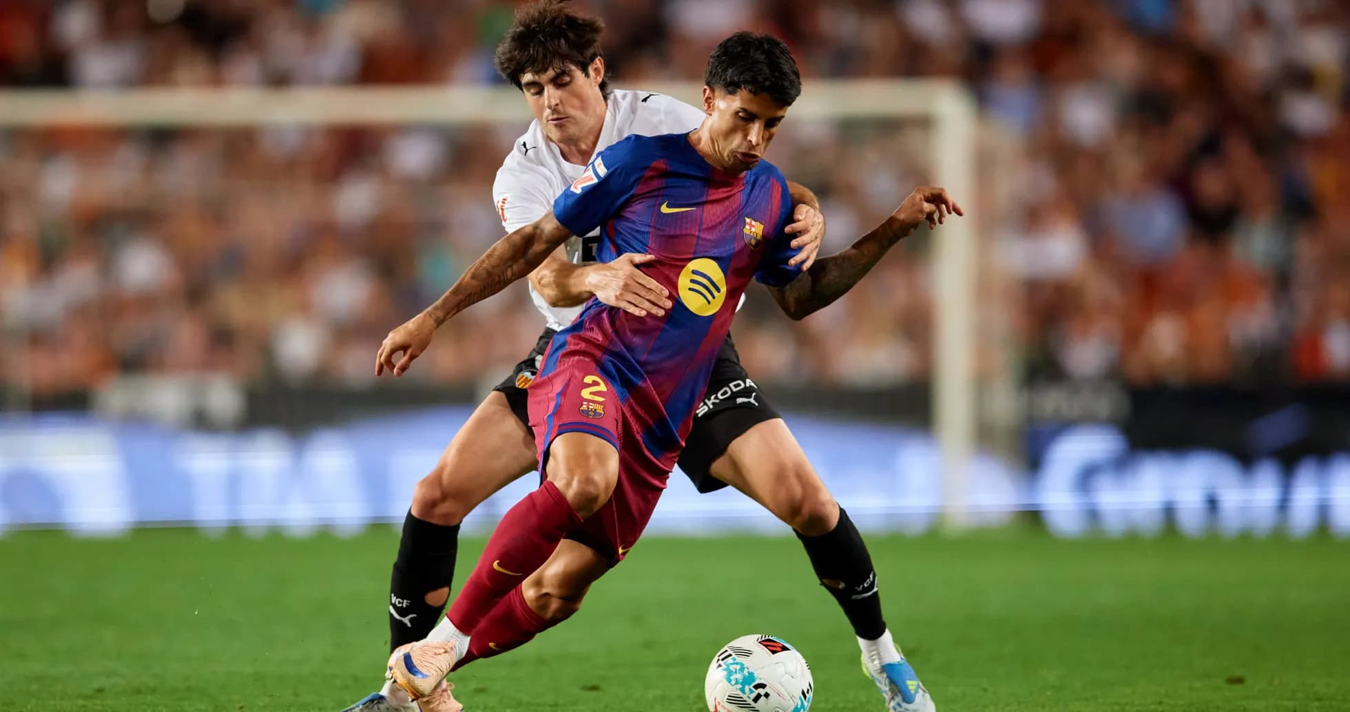 Jugador de Barcelona luchando por el balón con oponente Jugador de Barcelona luchando por el balón con oponente