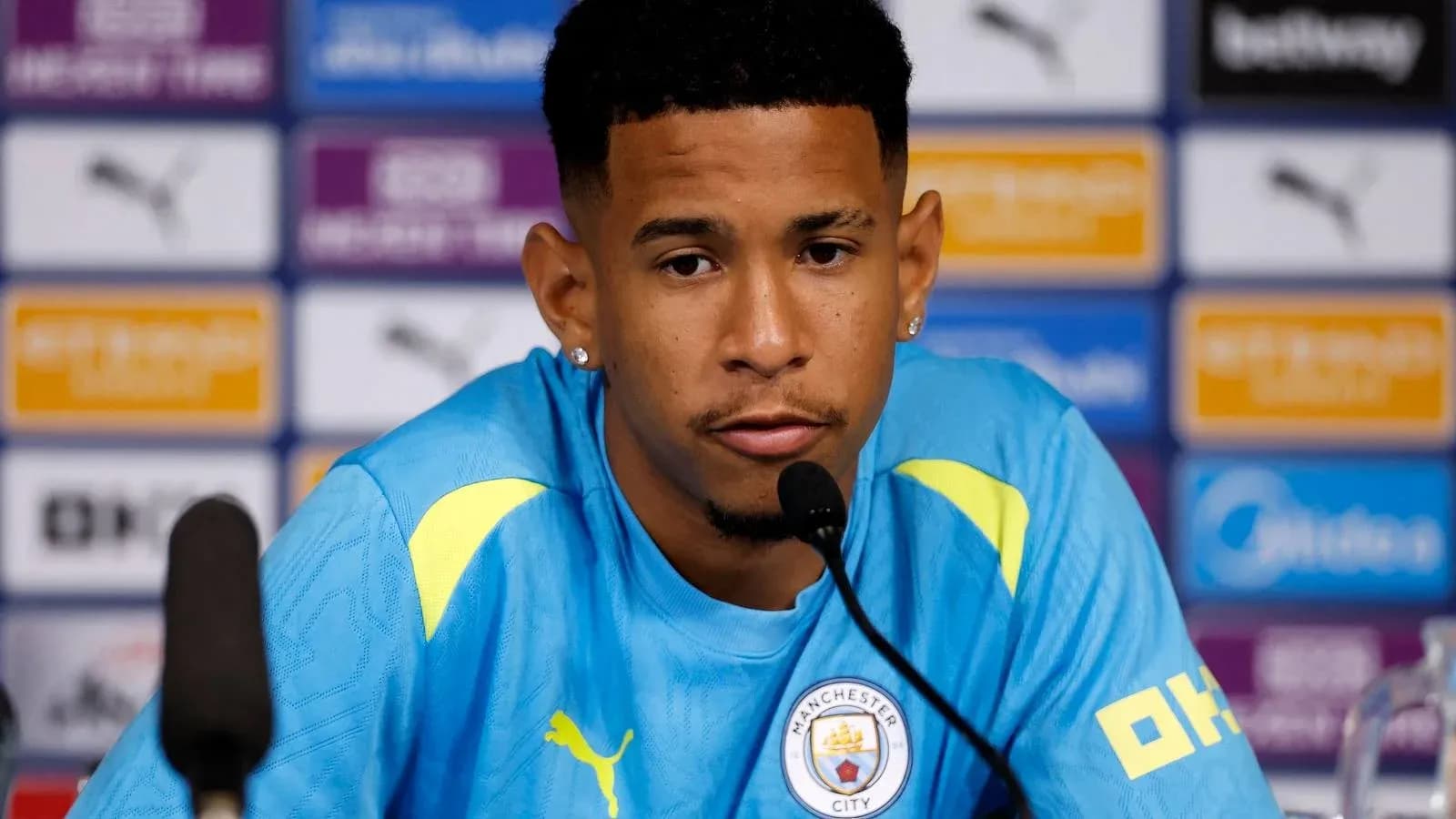 Jugador en conferencia de prensa con camiseta de Manchester City Jugador en conferencia de prensa con camiseta de Manchester City