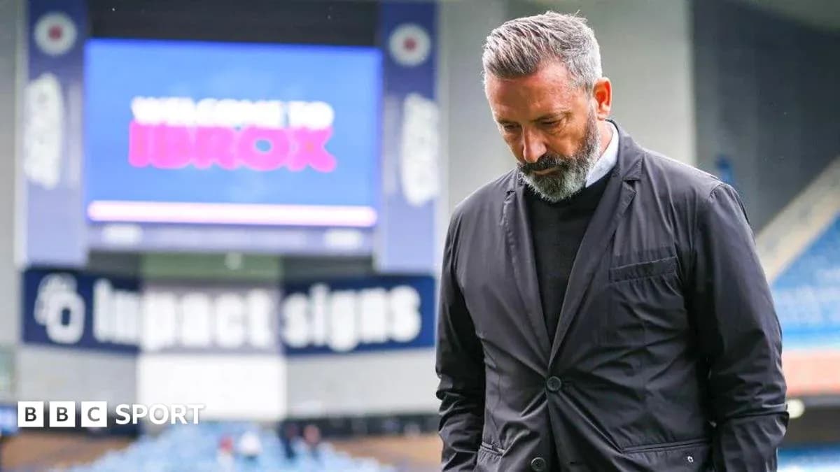 Entrenador caminando en Ibrox Stadium con mirada seria Entrenador caminando en Ibrox Stadium con mirada seria