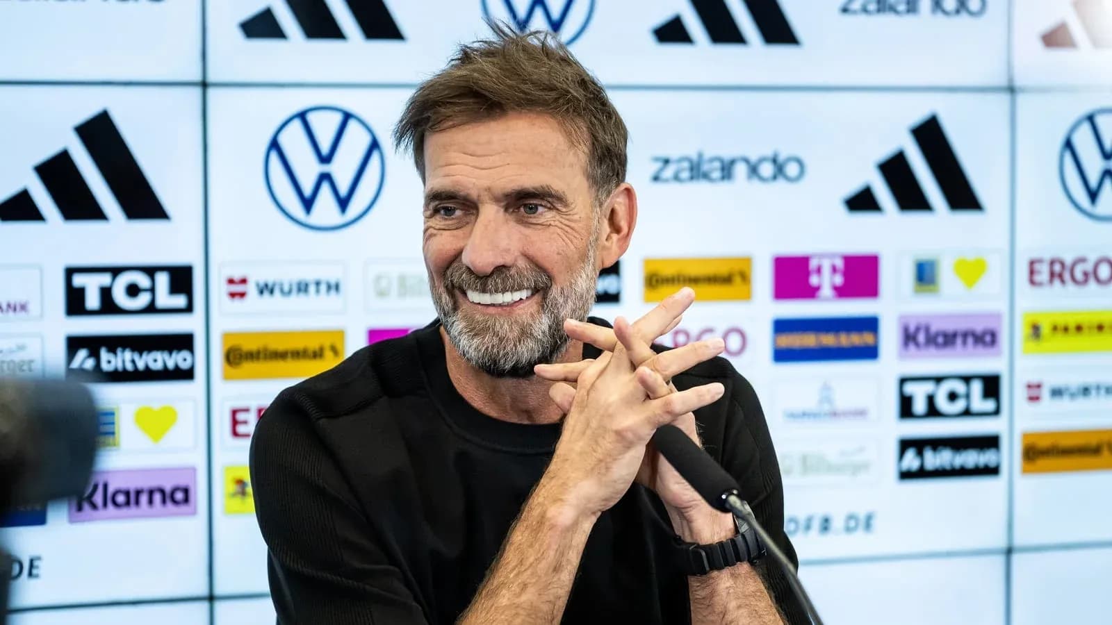 Entrenador en conferencia de prensa sonriente Entrenador en conferencia de prensa sonriente