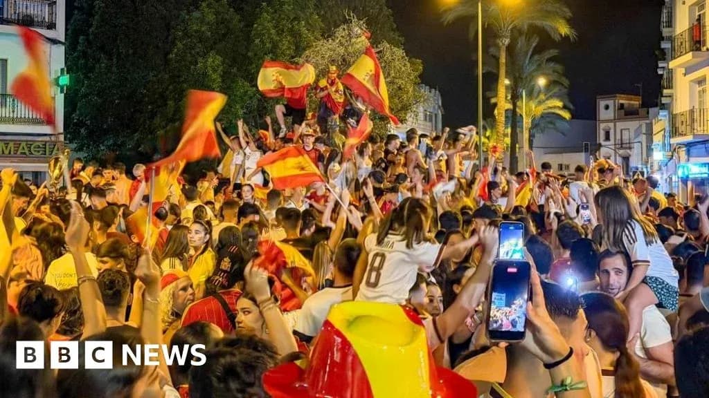Multitud celebrando con banderas españolas en la calle Multitud celebrando con banderas españolas en la calle