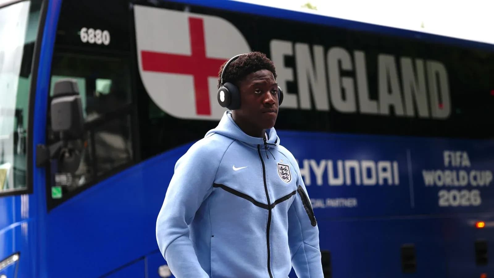 Jugador caminando junto a autobús de Inglaterra Jugador caminando junto a autobús de Inglaterra
