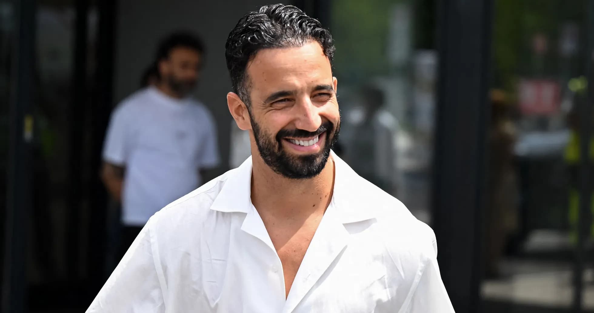 Hombre sonriendo con camisa blanca al aire libre Hombre sonriendo con camisa blanca al aire libre