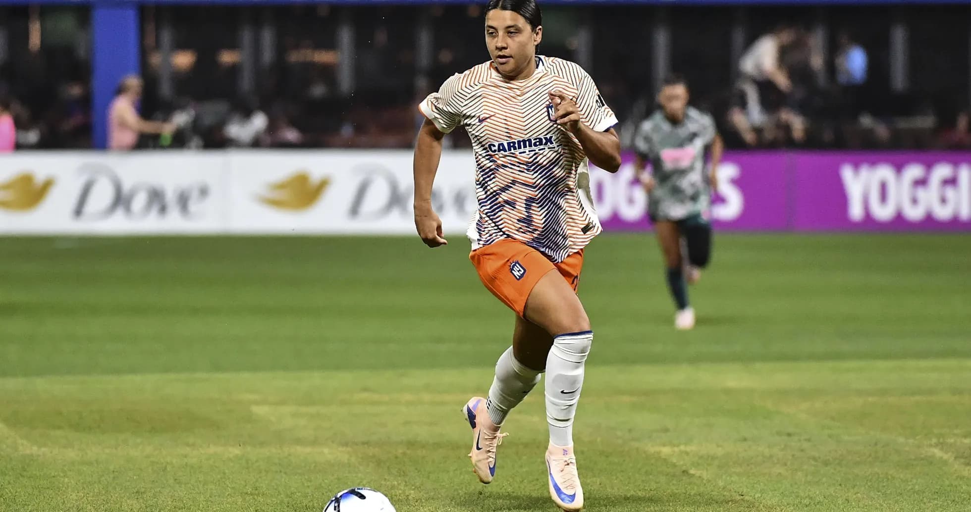Jugador corriendo con balón durante un partido Jugador corriendo con balón durante un partido