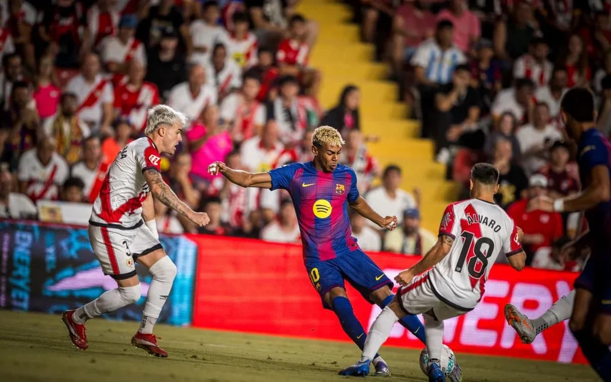 Jugador de Barcelona driblando a defensor de Rayo Vallecano Jugador de Barcelona driblando a defensor de Rayo Vallecano