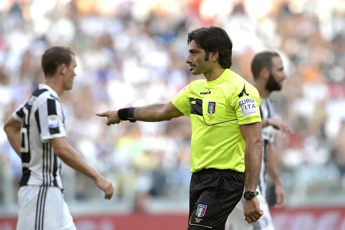 Árbitro dirigiéndose a jugador durante partido Árbitro dirigiéndose a jugador durante partido