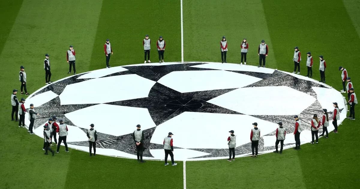 Equipo colocando el logo de la Champions League en el campo Equipo colocando el logo de la Champions League en el campo