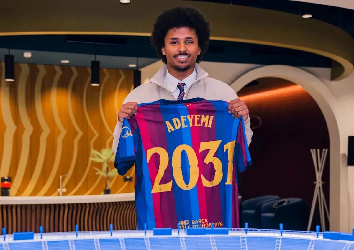 Jugador sosteniendo camiseta del Barcelona con nombre Adeyemi Jugador sosteniendo camiseta del Barcelona con nombre Adeyemi