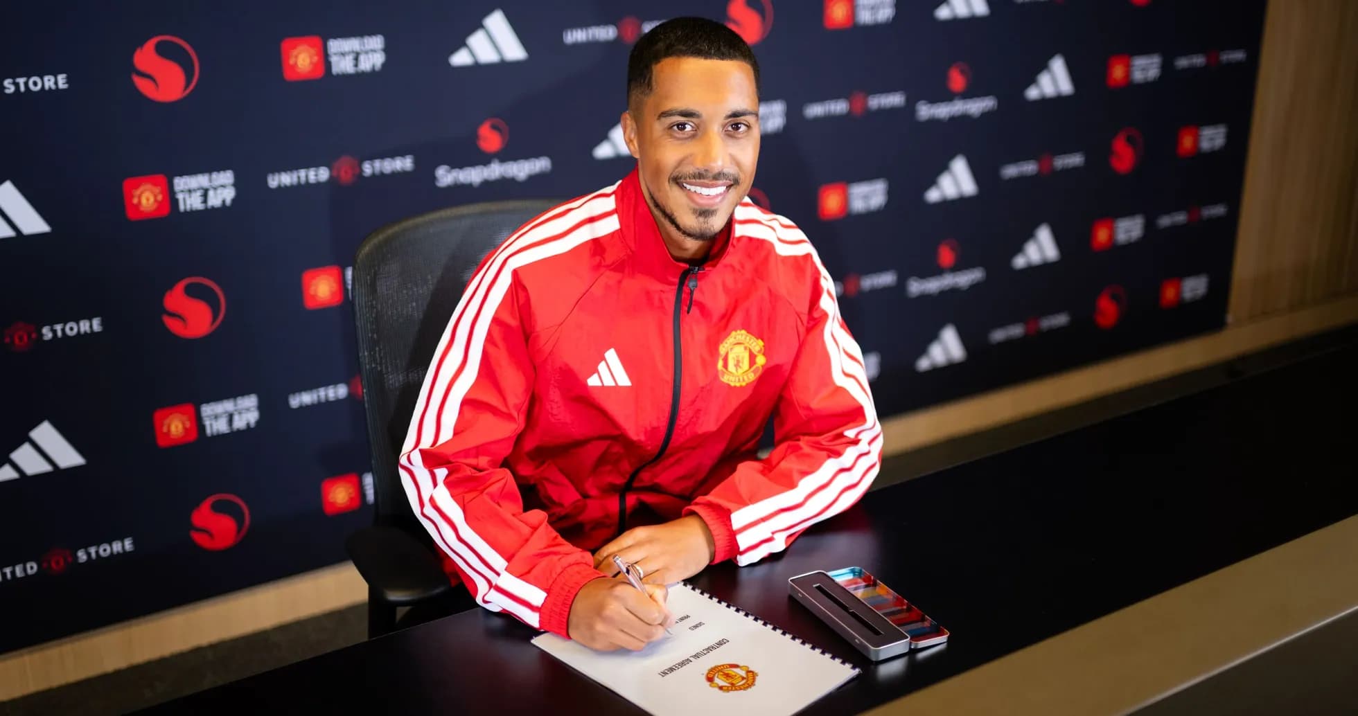 Jugador firmando contrato en presentación de club Jugador firmando contrato en presentación de club