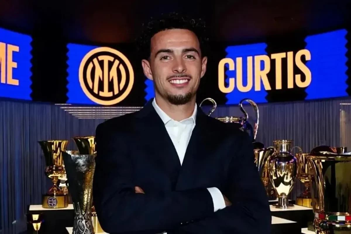 Persona sonriendo frente a trofeos en evento Persona sonriendo frente a trofeos en evento
