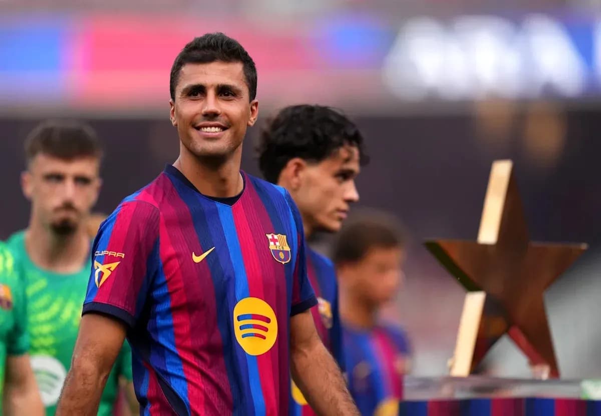 Jugador de Barcelona sonriendo con compañeros detrás Jugador de Barcelona sonriendo con compañeros detrás