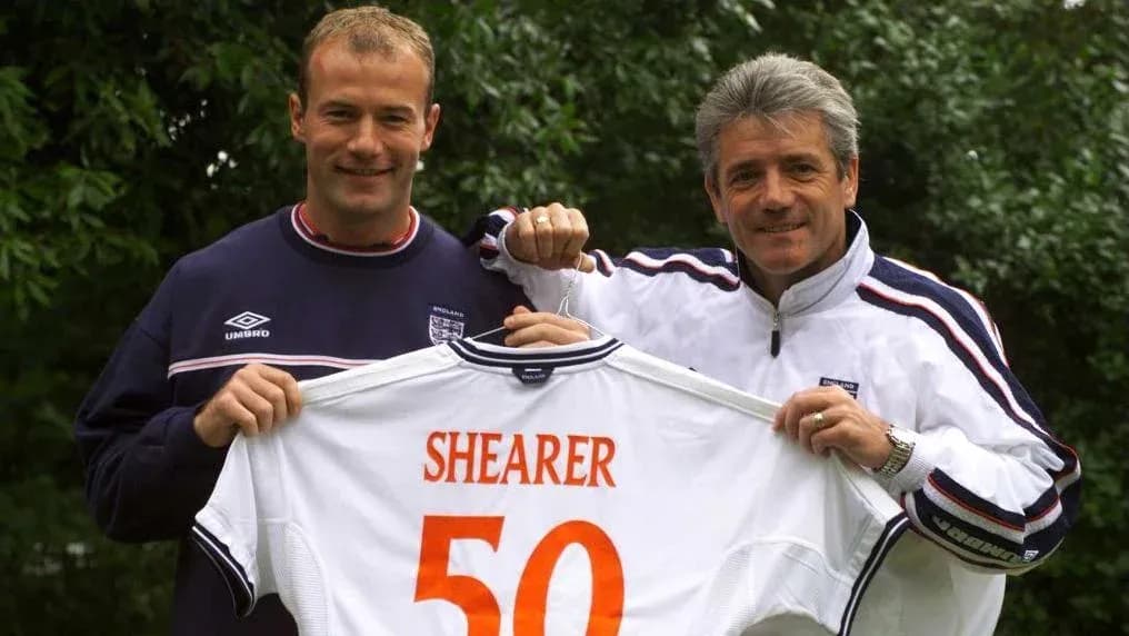 Jugador y entrenador sosteniendo camiseta con nombre Shearer Jugador y entrenador sosteniendo camiseta con nombre Shearer
