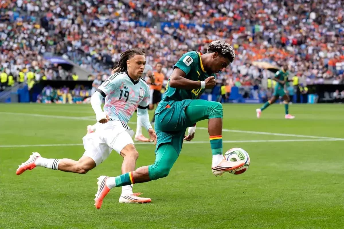Jugador de Camerún driblando a oponente en partido Jugador de Camerún driblando a oponente en partido