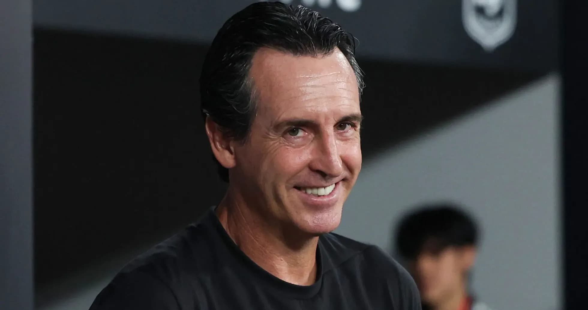Entrenador sonriendo en la banca durante el partido Entrenador sonriendo en la banca durante el partido