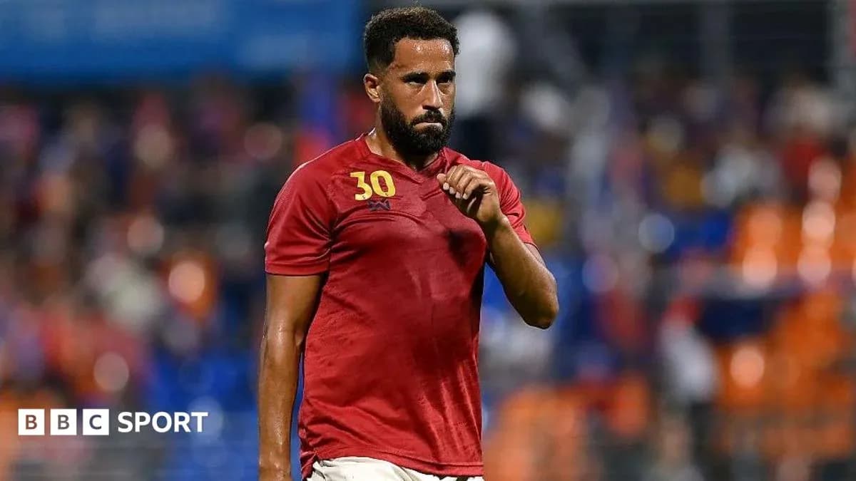Jugador en camiseta roja caminando por el campo Jugador en camiseta roja caminando por el campo